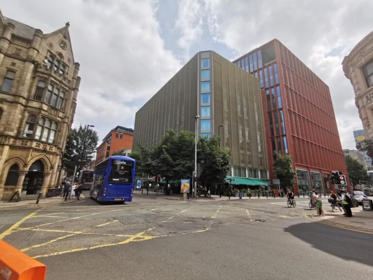 Street view of urban architecture with people and blue bus