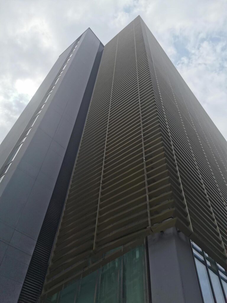 Modern skyscraper reaching towards the sky with cloudy backdrop