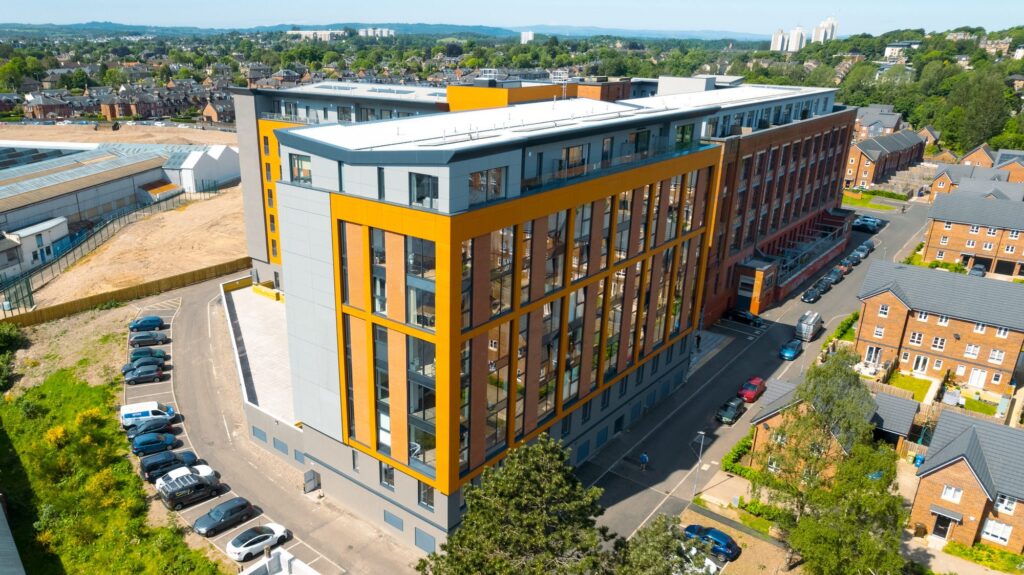 Modern urban apartment building with vibrant orange accents
