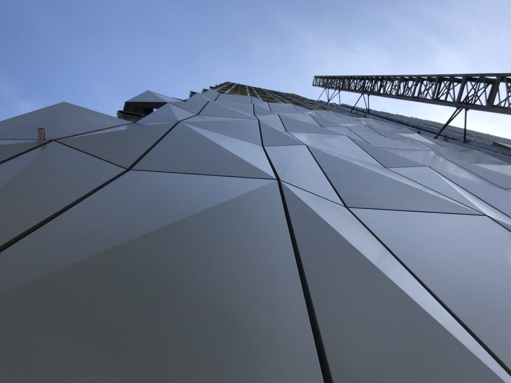 Futuristic building with geometric facade under blue sky
