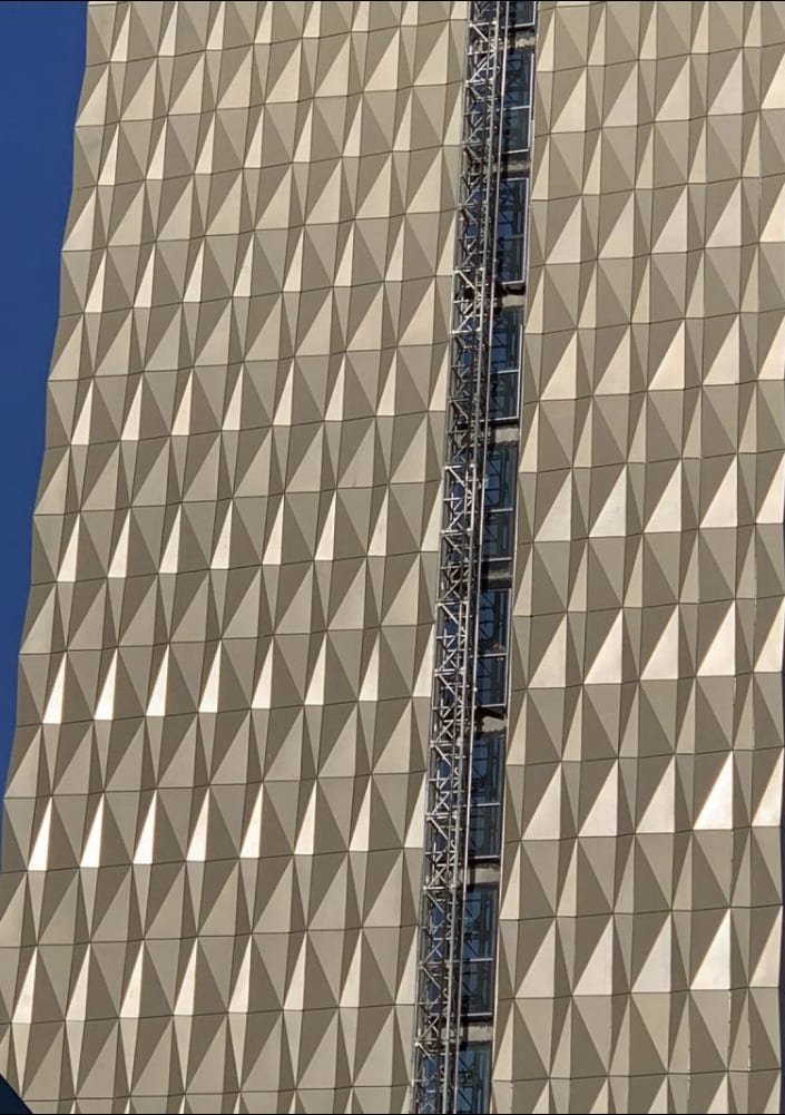 Modern building with geometric facade and clear blue sky