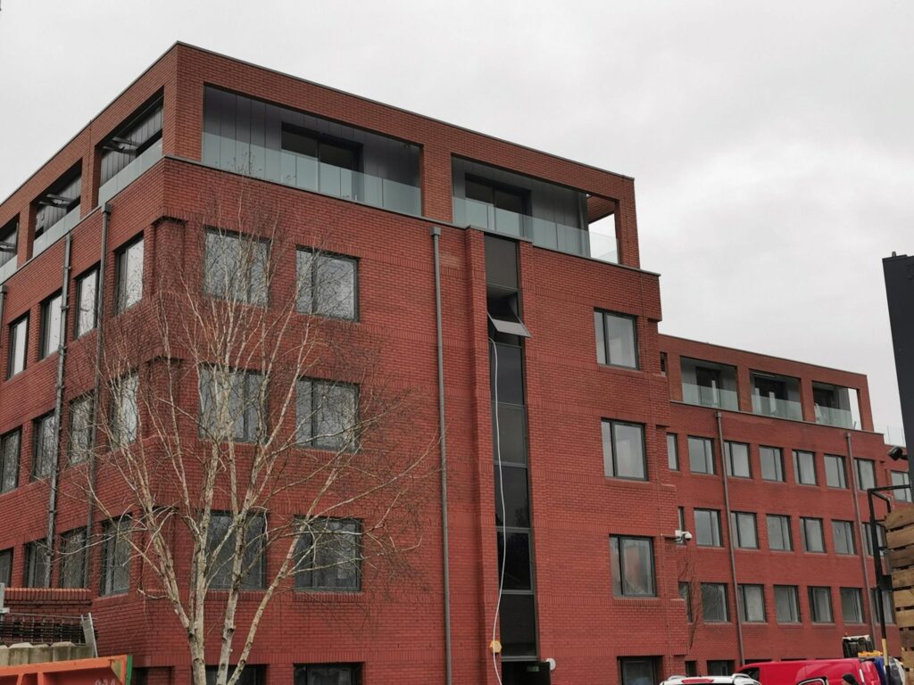 Modern red brick office building on cloudy day