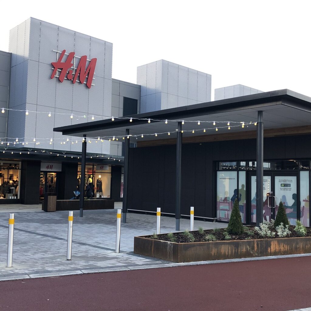 Modern shopping center exterior with clothing store entrance