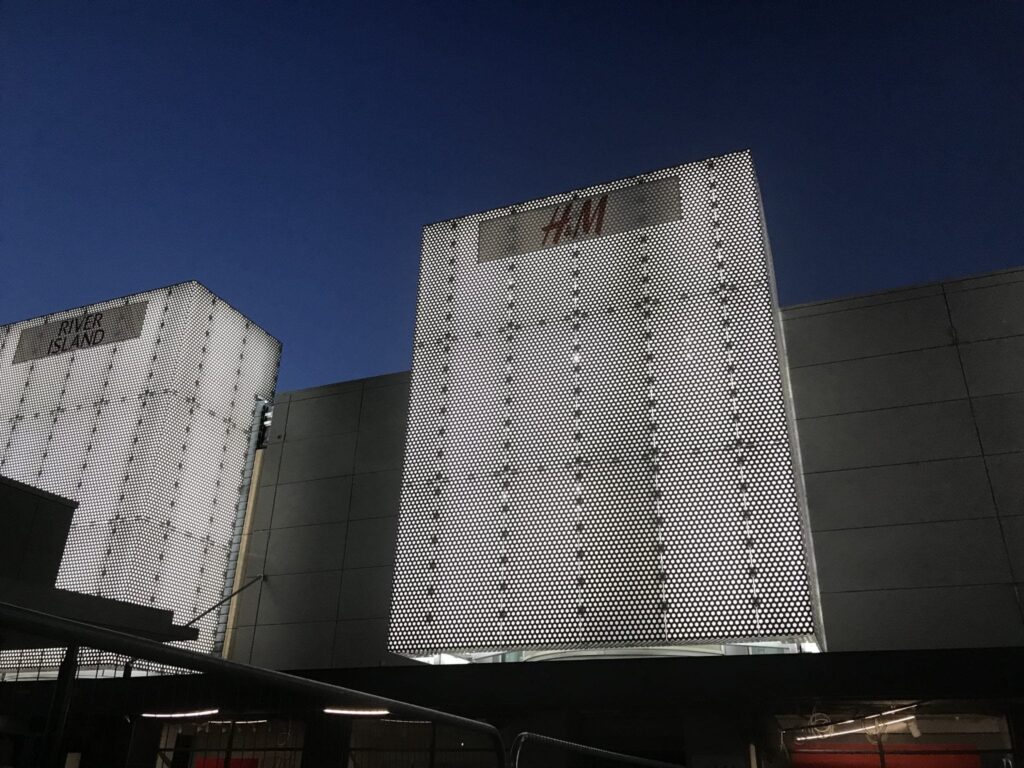 Illuminated shopping center facade at night with modern design