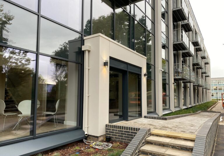 Modern office building with glass facade and outdoor seating area
