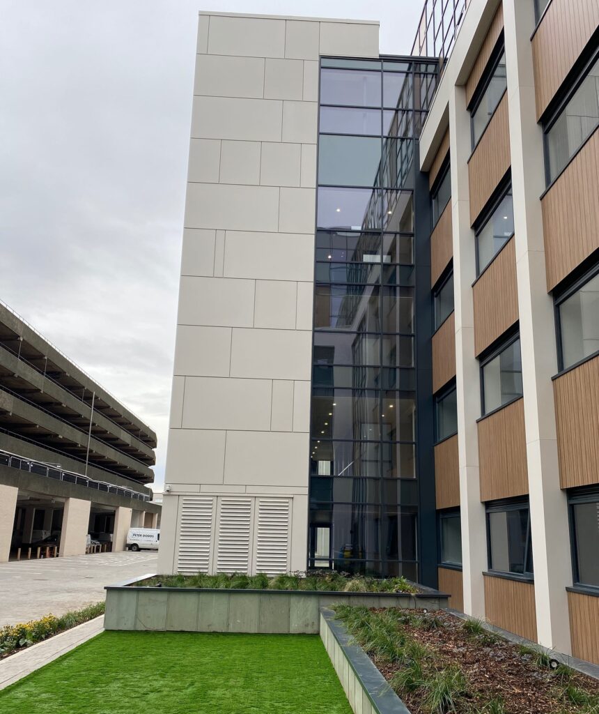 Modern office building exterior with large windows and greenery
